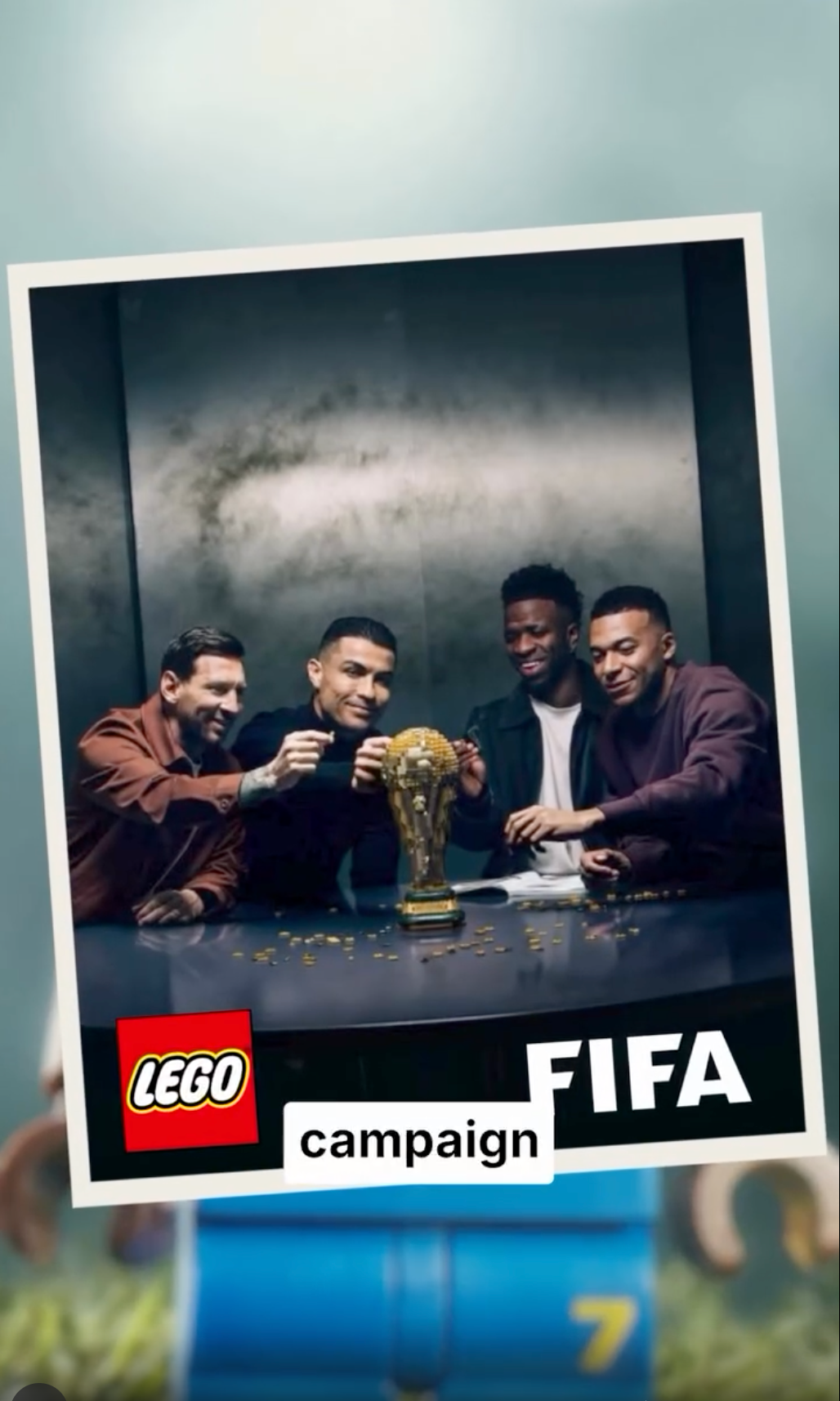 Four football players gather around a LEGO trophy above the LEGO and FIFA logos.